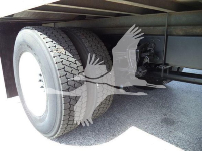 Refrigerated truck rear axle showing dual rear tires and undercarriage components.