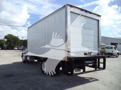 Side/rear view of a 2015 Hino 268A refrigerated truck with white box, rear doors, and black underruns; VIN and stock info not visible on vehicle.