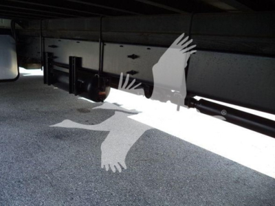 Underneath view of a 2015 Hino 268A refrigerated truck showcasing undercarriage components and frame with shadows