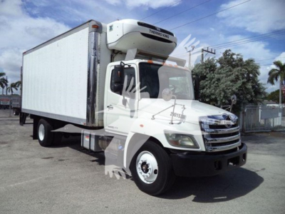 2015 Hino 268A refrigerated box truck with Thermo King unit on cab, white cargo box, side view showing front grille and windshield. Text visible includes Hino branding on grill and Thermo King label on roof unit.