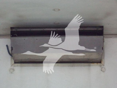 Refrigerated truck cargo area vent with a black metal vent hatch mounted to a white trailer wall.