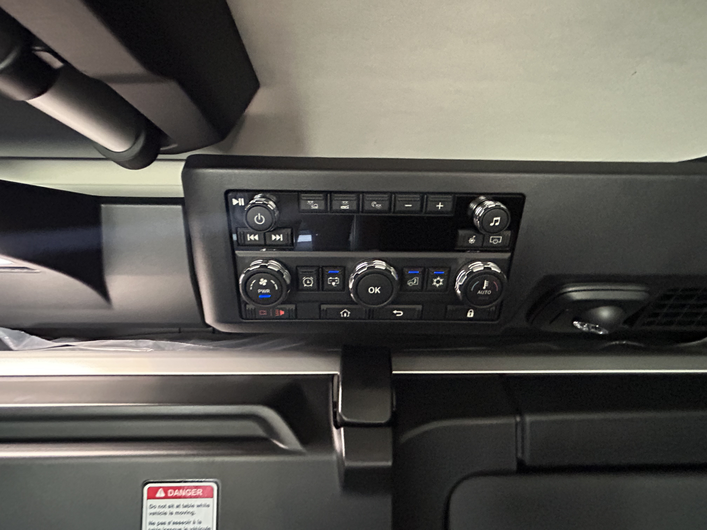 Cab controls panel in a Mack PR64T76H truck showing climate control and radio interface from a low-angle view