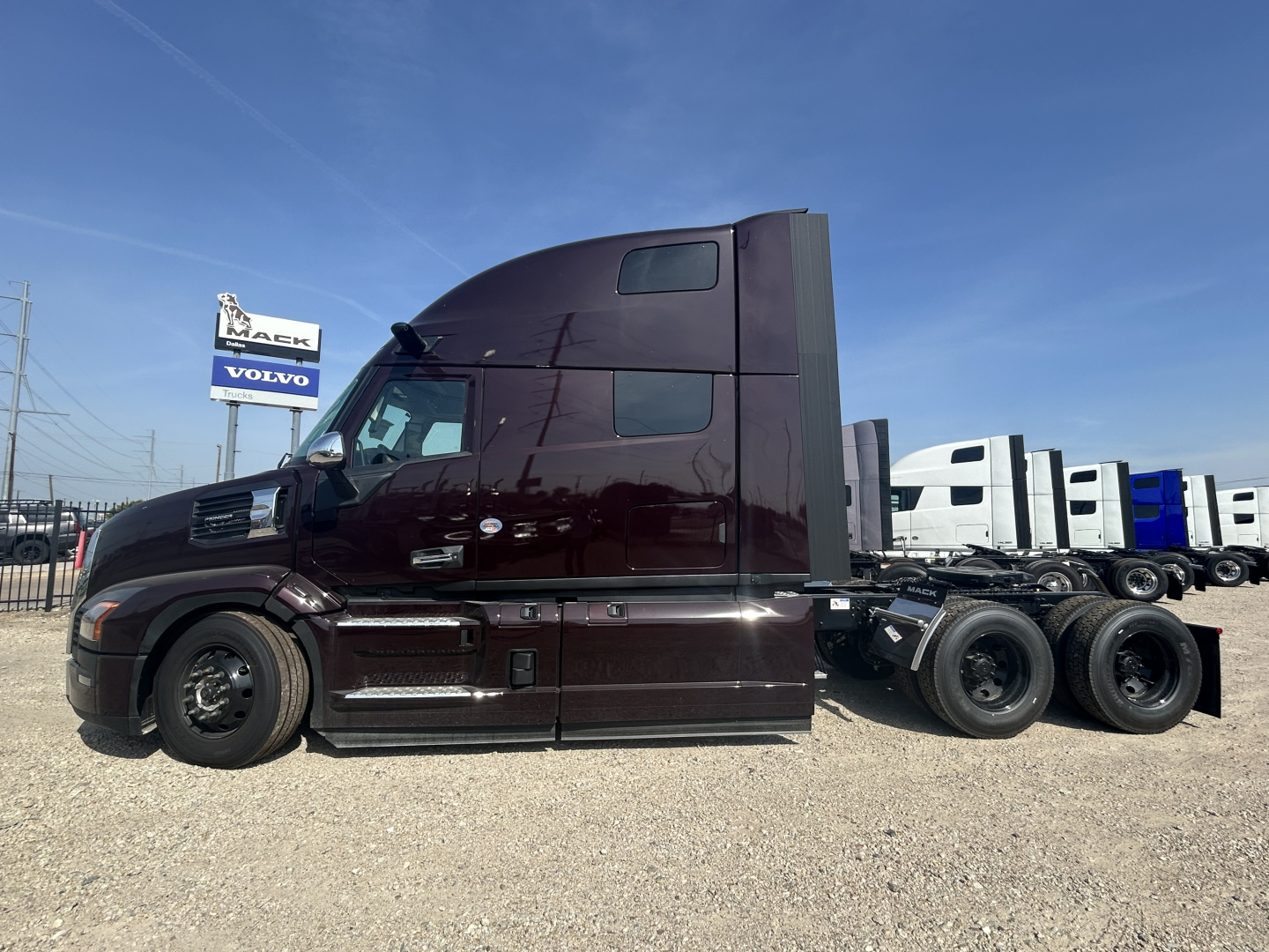 Mack PR64T76H conventional sleeper truck side view showing dark maroon cab and multiple rear axles.