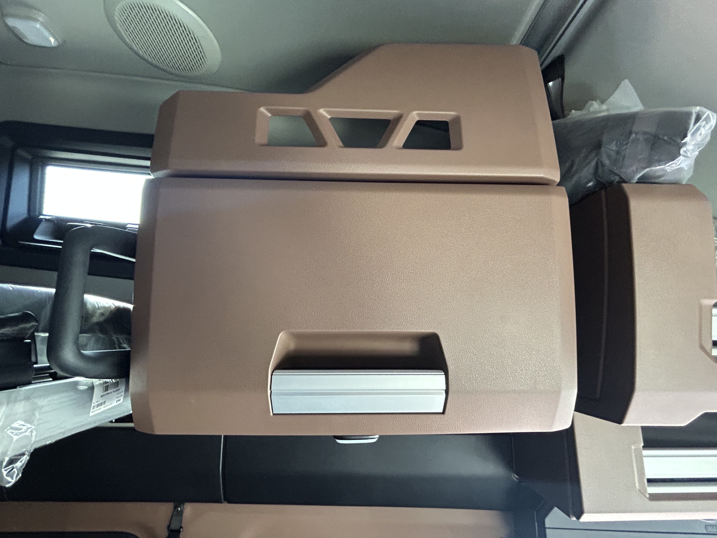 Mack PR64T76H engine bay showing tan sleeper cab interior components and storage compartments.