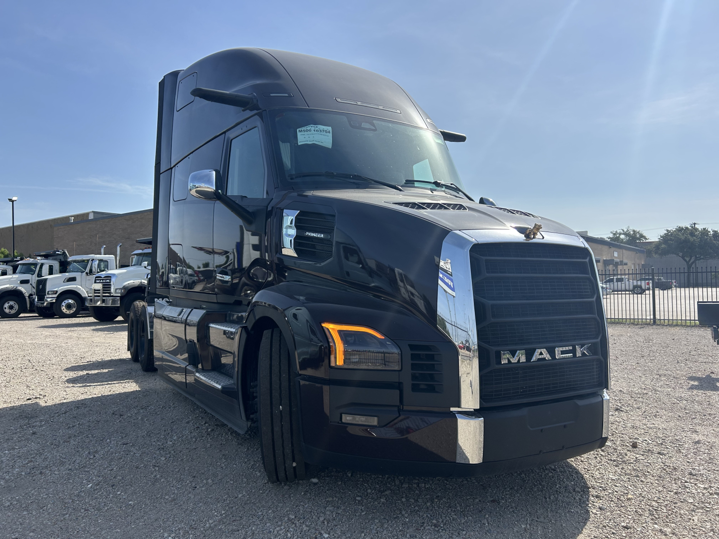 Mack PR64T76H sleeper tractor in black, front left view with chrome grille and orange turn signals.