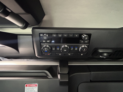 Cab controls panel in a Mack PR64T76H truck showing climate control and radio interface from a low-angle view