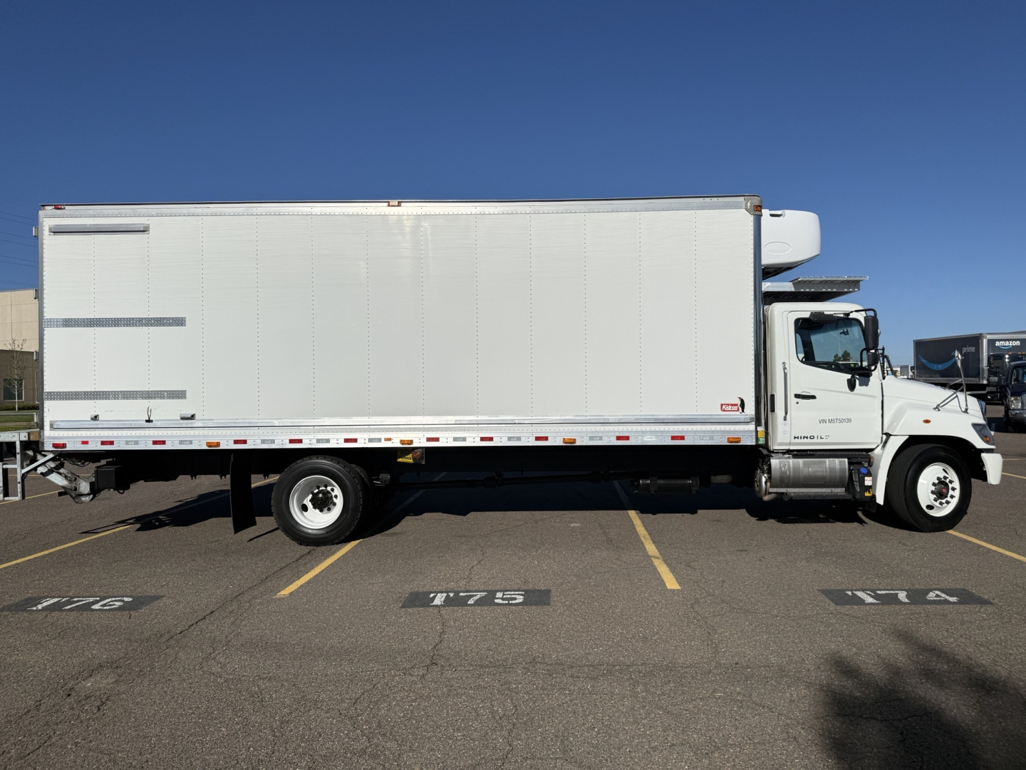 Side view of a white refrigerated 2021 Hino 338 box truck with VIN 5PVNV8AV2M5T50139 and stock number 0628579 visible.