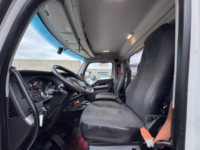 Kenworth truck cab interior with steering wheel, dashboard, and driver seat visible.