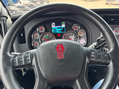 Kenworth T680 steering wheel and instrument cluster view in cab showing gauges and multifunction controls.