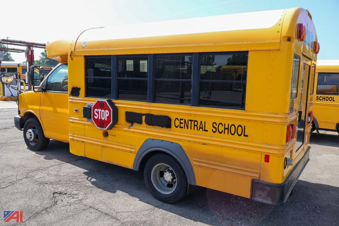 School bus in-service side view showing yellow body, black window frames, and 'CENTRAL SCHOOL' text with stop sign on the side.