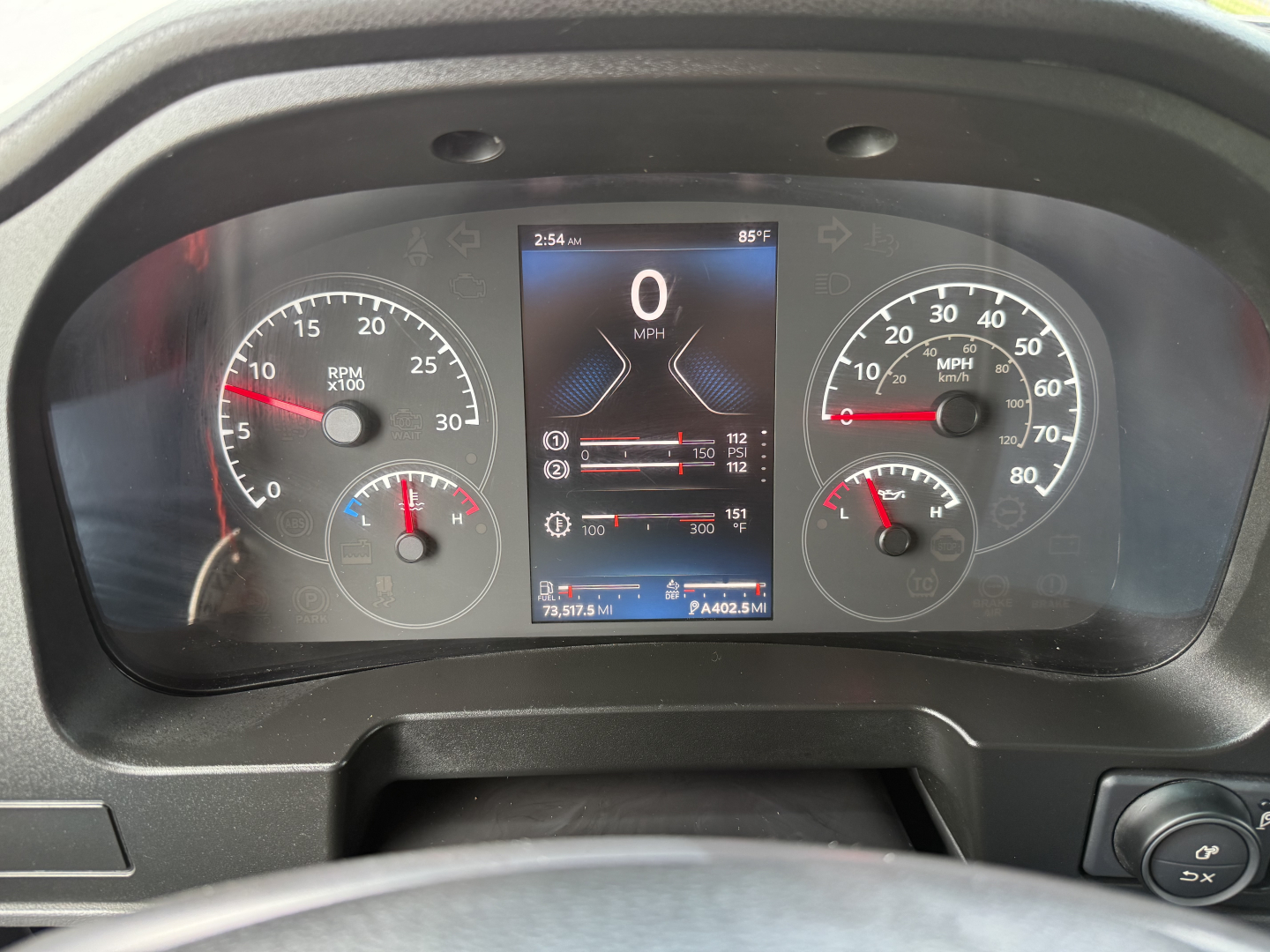 Dashboard display of a Kenworth T380 truck showing 0 mph on central digital screen, left gauge RPM, right gauge speed, various indicators and dials, with temperature 85F.