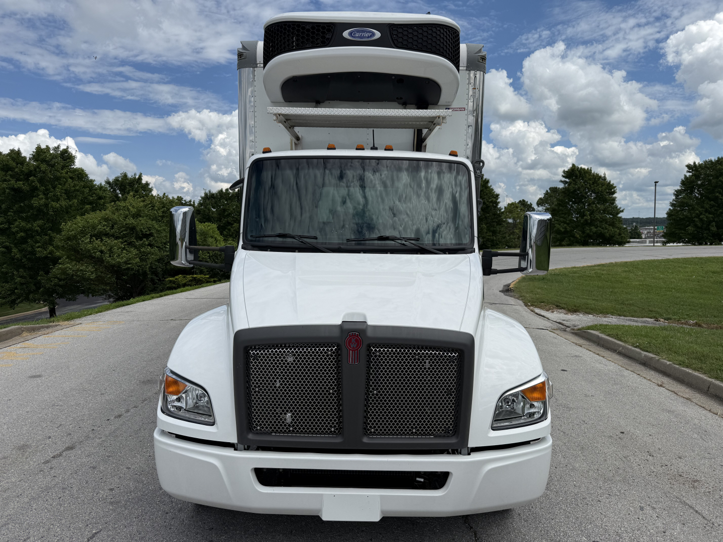Kenworth T380 refrigerated box truck front view showing cab, grille, and rooftop refrigeration unit mounted behind cab.