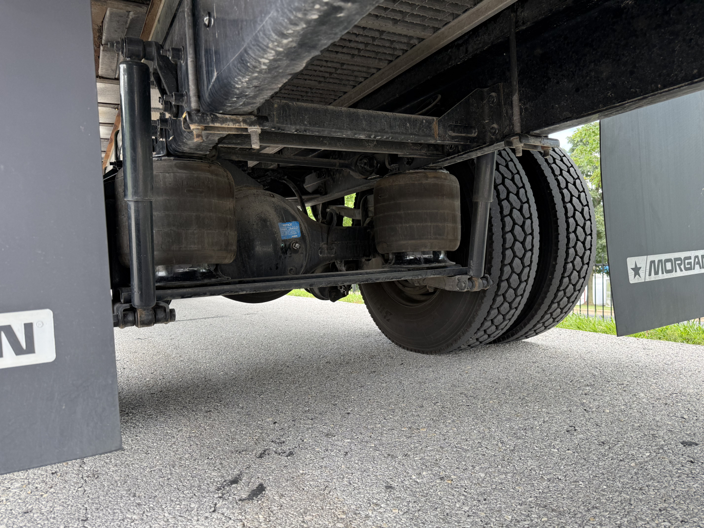Kenworth T380 undercarriage showing rear axle and suspension components and a portion of the refrigerated trailer.