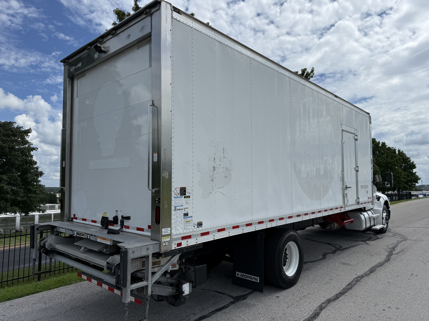 Kenworth T380 refrigerated truck side rear view showing cargo box and rear undercarriage with white cab