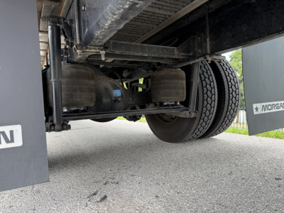 Kenworth T380 undercarriage showing rear axle and suspension components and a portion of the refrigerated trailer.