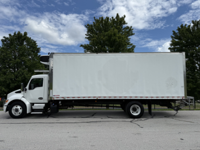 Kenworth T380 refrigerated truck side view with white box, cab in front, black tires, logo not legible, no visible text on the box aside from reflective stripe and minor decals.
