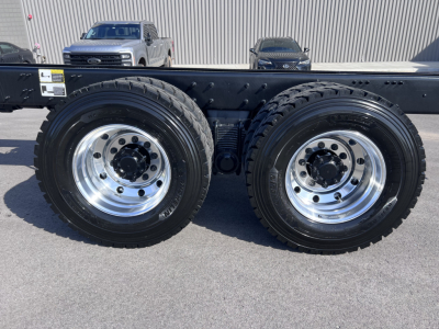 Dual rear axle wheels on a Mack GR64B cab and chassis showing chrome rims and heavy-duty tires with suspension components in the frame.