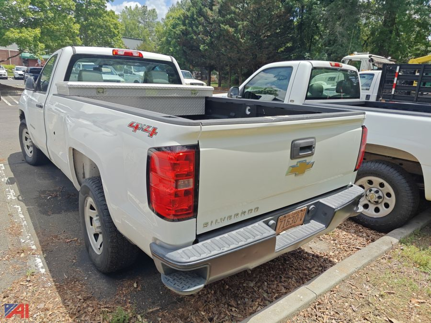 Chevrolet Silverado 1500 pickup truck rear view 4x4 badge and bed with tonneau cover in a parking lot.