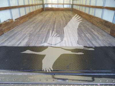 Truck bed interior of a 2019 Hino 268A with wooden floor and metal sidewalls, empty cargo area.