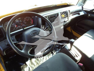 Truck cabin interior showing steering wheel, dashboard with gauges, center console, and seating area.