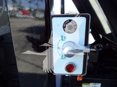 Isuzu NRR control panel with flip lever labeled ON OFF, UNLOCK DOWN, and brake level, plus a red emergency push button. Some text includes OFF, UNLOCK, UP/DOWN with icons.