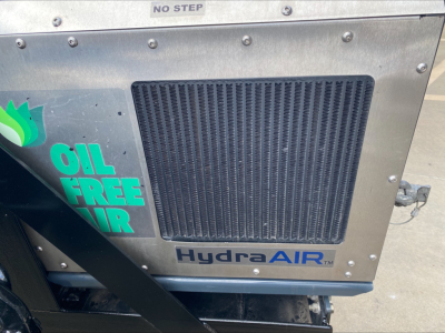 Front side of a Peterbilt 389 truck engine bay showing HydraAIR and Oil Free Air branding on the radiator cover.