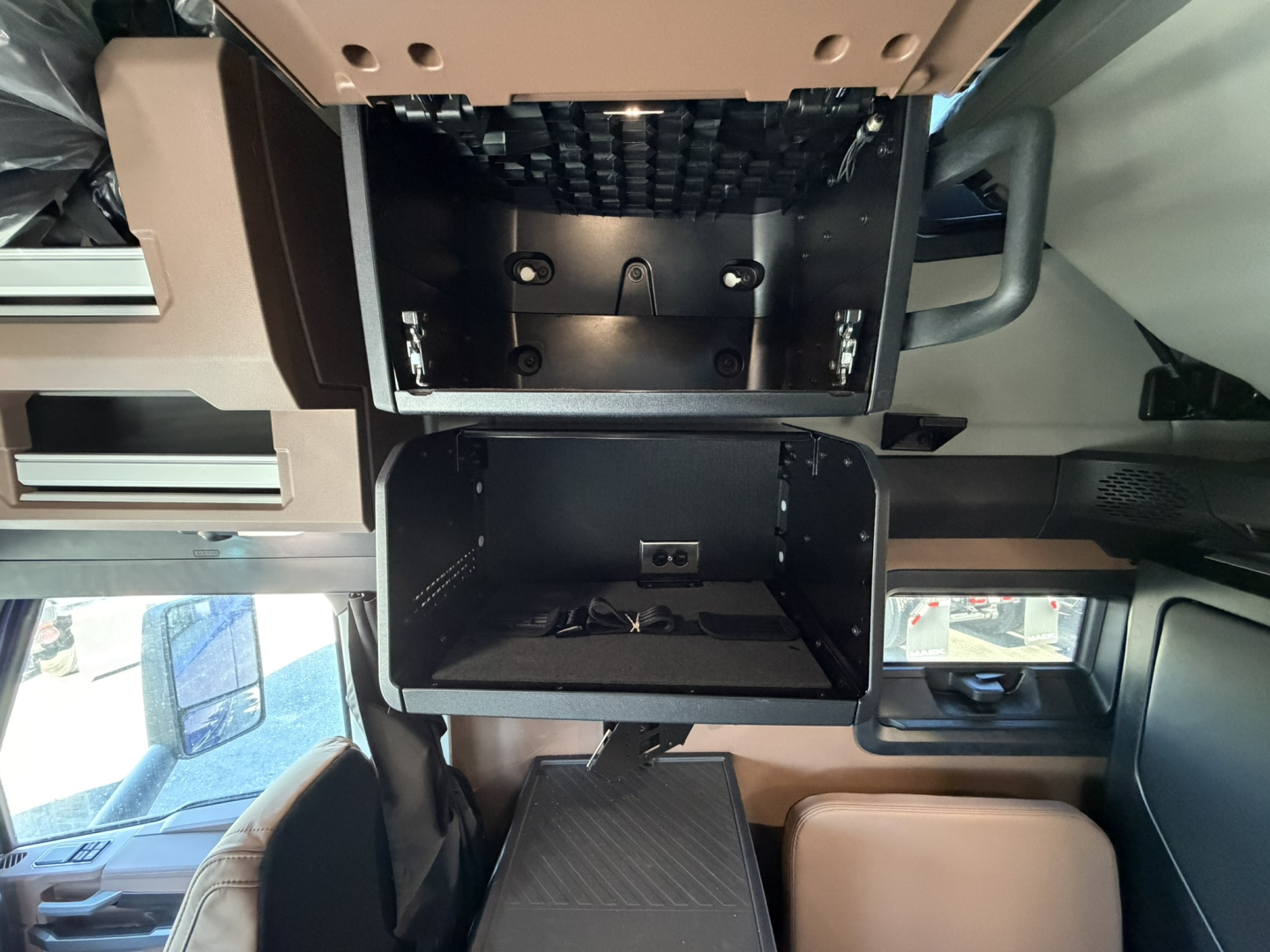 Cab interior showing overhead storage compartments and dashboard opening in a Mack PR64T76H truck cab.
