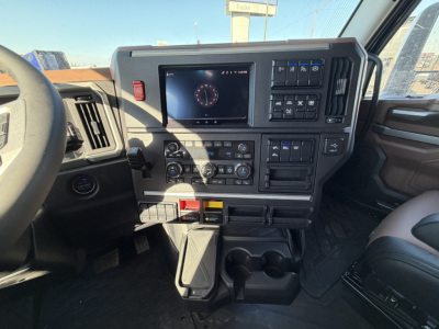 Mack PR64T76H truck cab interior dash with touchscreen display and controls, steering wheel on left, center console with climate and media panels.
