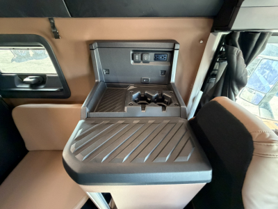 Mack PR64T76H interior console with fold-down table, cup holders, power outlets and USB-C ports visible.