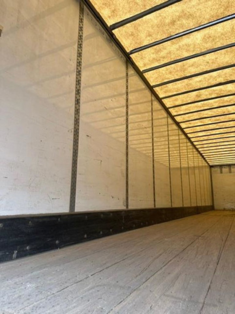Trailer interior cargo area of a 2016 Wabash van showing empty wooden floor and side walls with metal rails.