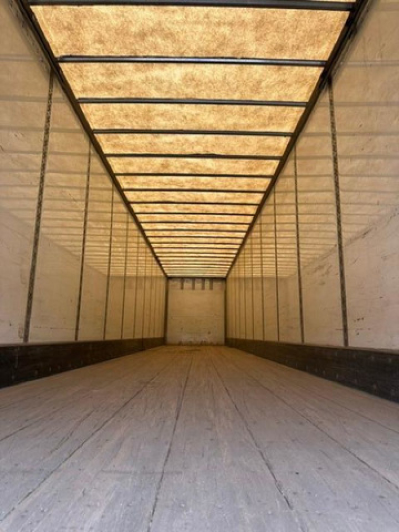Trailer interior: empty longitudinal cargo area with wooden ceiling panels and side walls.