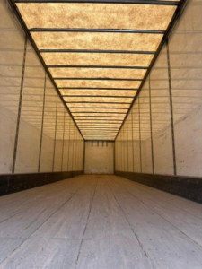 Trailer interior: empty longitudinal cargo area with wooden ceiling panels and side walls.