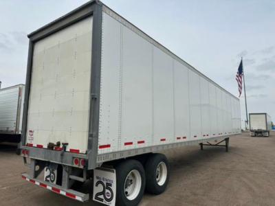Trailer side view showing a white Wabash van trailer with dual rear axles and a rear door; stock No U90914 visible with U.S. flag in background.