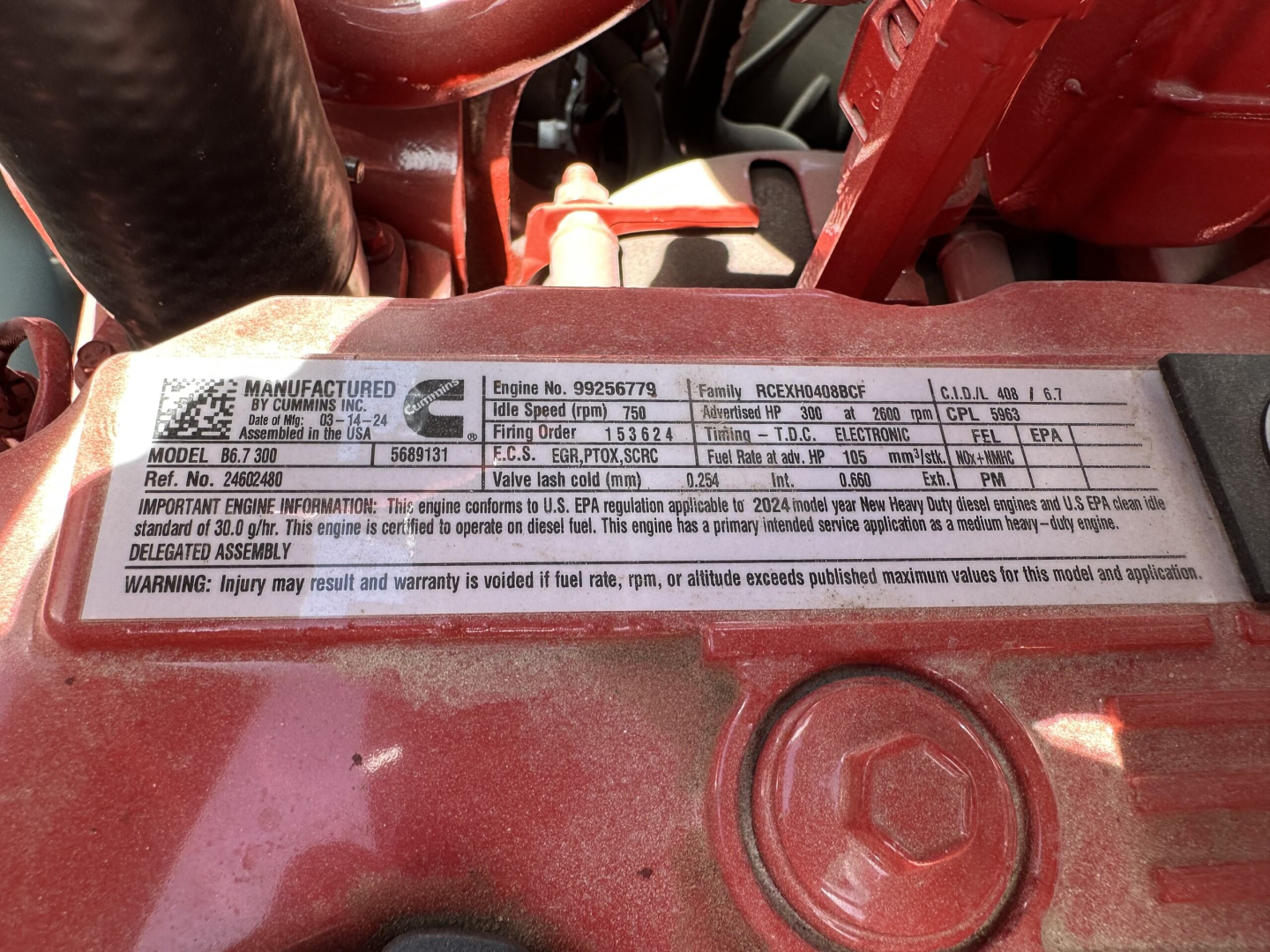 Mack MD7 engine data plate showing model number, engine serial, fuel rate and EPA information. Visible text includes 'MANUFACTURED BY ... ENGINE NO. 9256679' and other specifications, on a metallic engine tag.