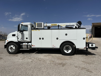 Service/utility truck side view showing utility compartments and crane equipment on a white Mack MD7 chassis.