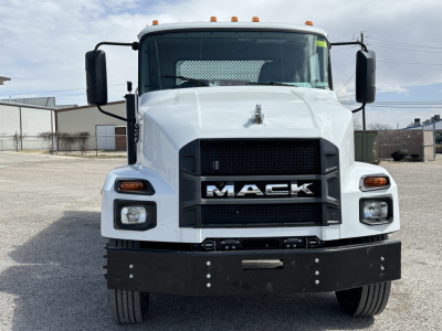 Front view of a white 2025 Mack MD7 service truck showing bold grille with MACK logo and black front bumper.