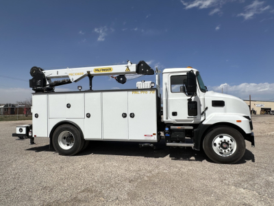 Mack MD7 service truck with bucket lift, side compartments and crane, showing clean white cab and utility body.