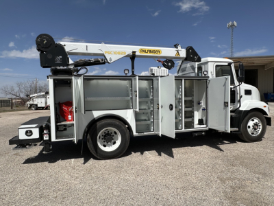 Service/Utility truck with Palfinger crane and open compartments showing storage bays and equipment rack on a white Mack MD7 chassis.