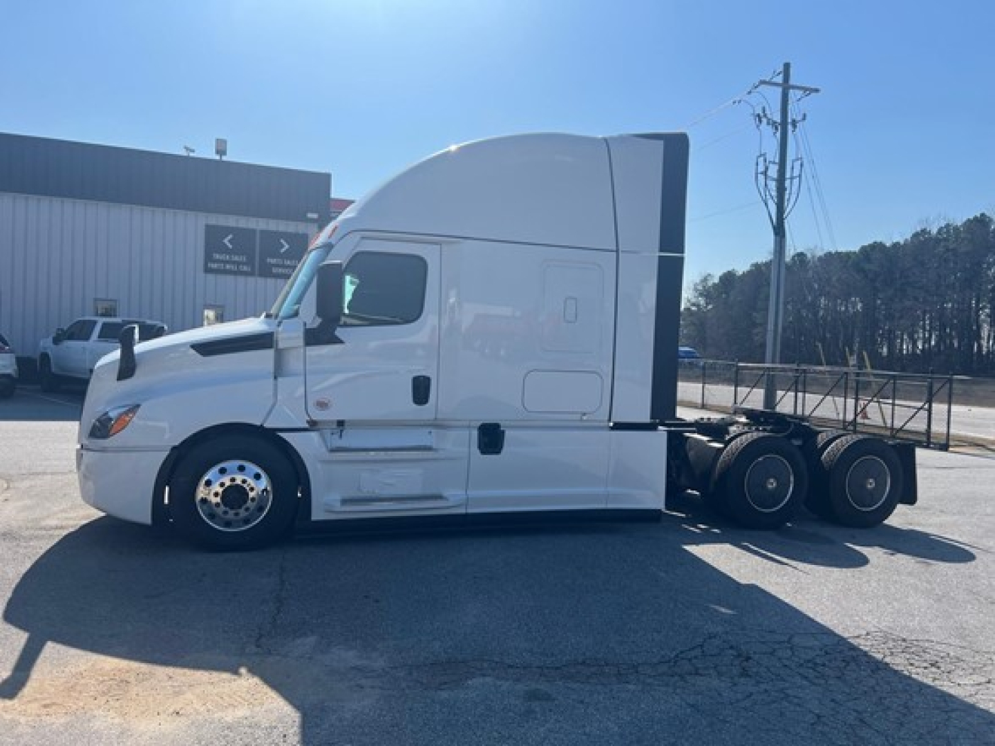 Freightliner Cascadia 126 sleeper cab tractor side view showing white exterior and dual rear axles.