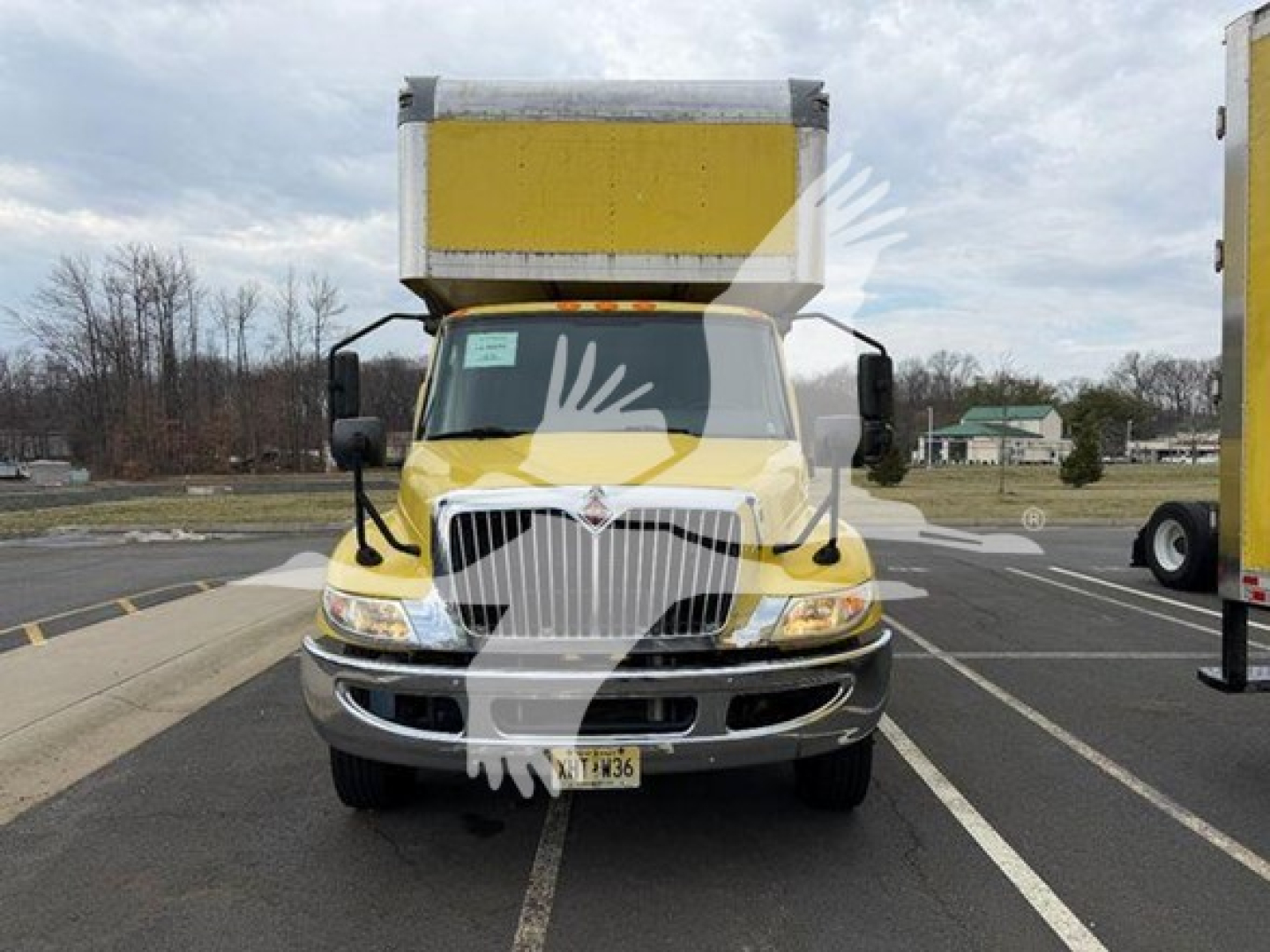 Front view of a yellow 2020 International MV moving van truck showing the grille and cargo box.
