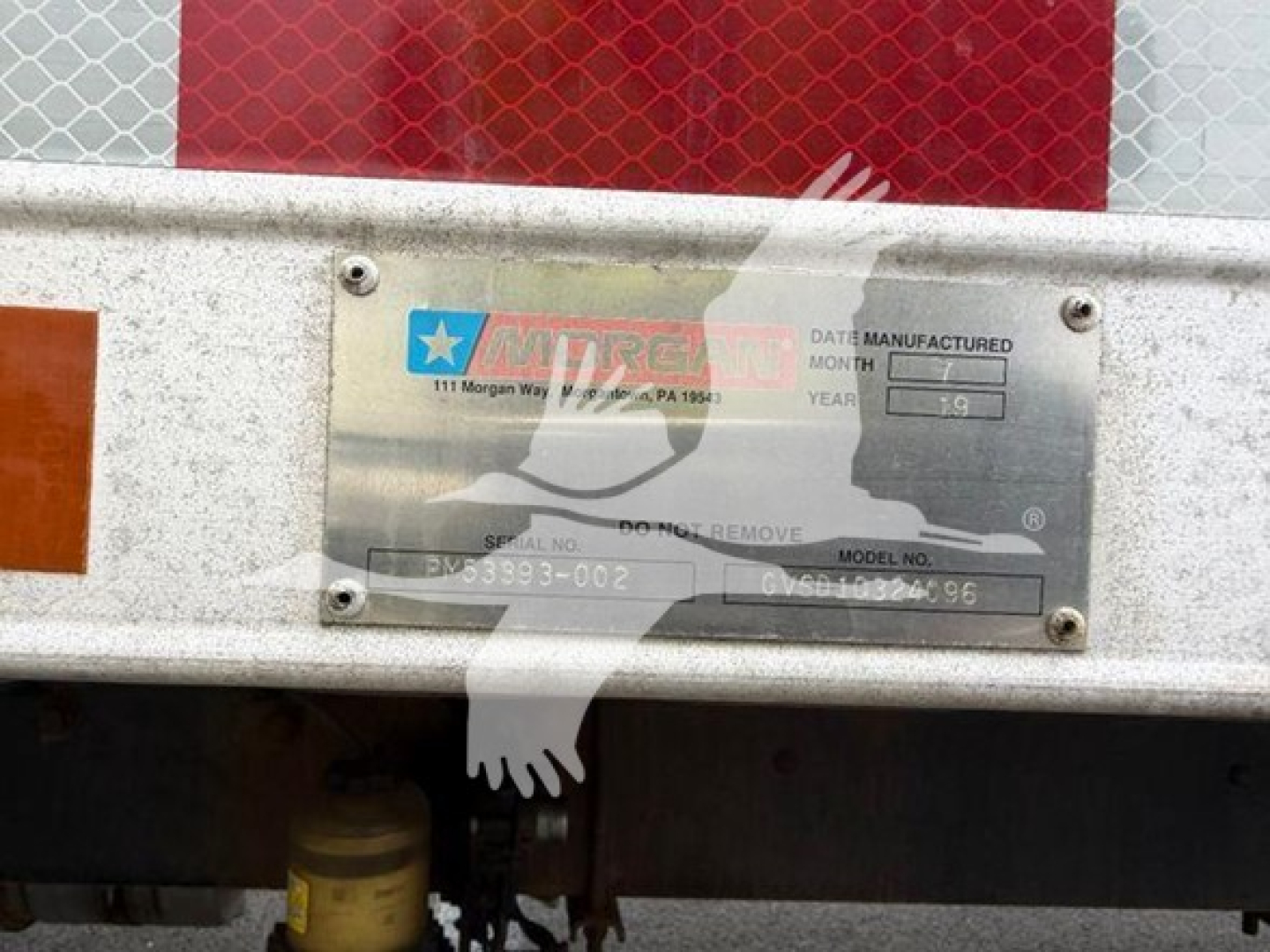 Moving van rear showing manufacturer's data plate with model and serial numbers and a metal frame.