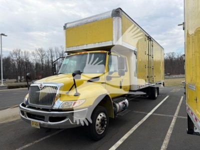 Truck cab and box in a moving van with yellow exterior, front grille, headlights, large side mirror, and box trailer attached.