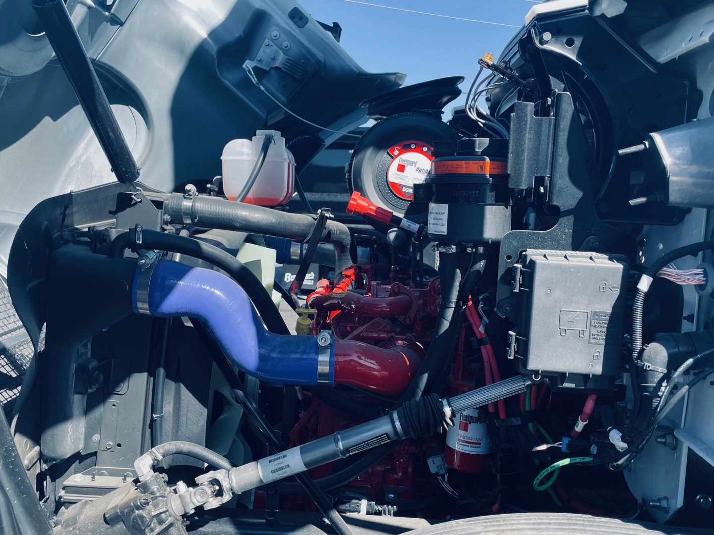 Mack MD6 engine bay showing turbocharger, hoses, and electrical wiring with red engine block and blue hose.