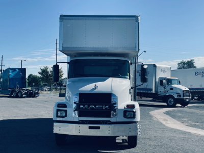 Front view of a 2026 Mack MD6 dump truck showing the grille with MACK badge, large white bumper, and raised dump bed.