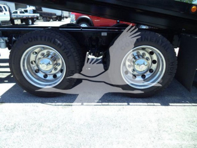 Kenworth T880 rollback truck dual rear wheels with Continental tires and polished rims; side view of wheel area.