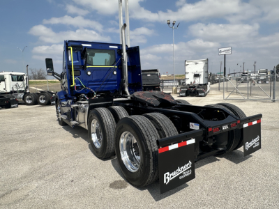 Volvo VNR truck chassis with three rear axles and mud flaps showing Goodyear tires and chrome wheels.