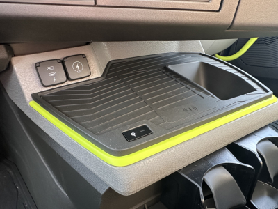Volvo VNR64T300 dash area showing wireless charging pad and cup holder with surrounding lime-yellow accent trim.