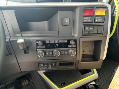 Volvo VNR64T300 dashboard showing climate controls and switches, center console with USB/12V ports, and storage pocket.