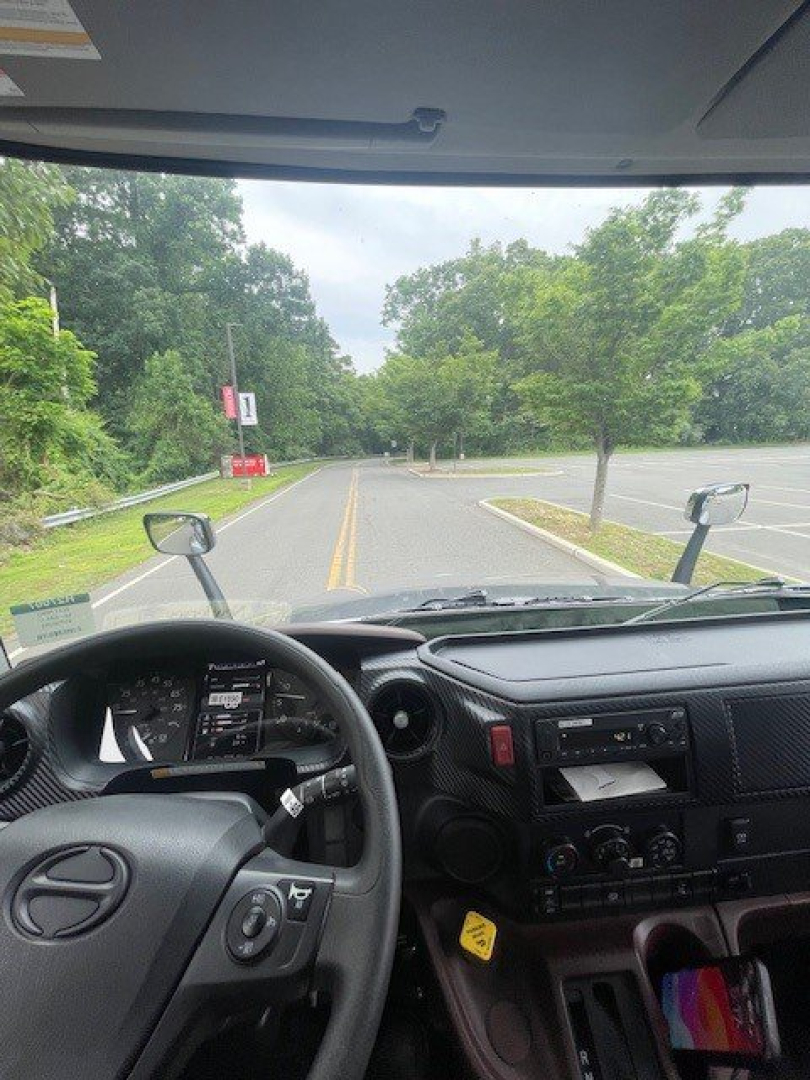 Cab interior of a 2027 Hino L6 truck showing steering wheel, instrument cluster, center console, and dashboard controls.