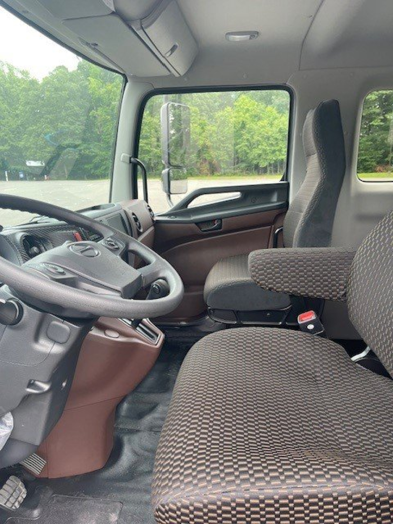 Cab interior of a 2027 Hino L6 truck showing driver's seat, steering wheel, and front passenger seat with patterned upholstery.